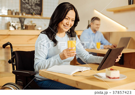 Cheerful handicapped woman drinking juice 37857423