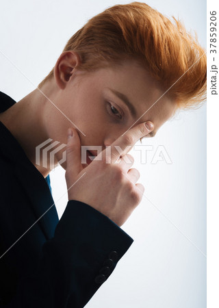 Preoccupied red-haired young man thinking 37859206