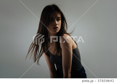 Pretty serious woman looking over her shoulder Pretty serious woman looking over her shoulder 37859641