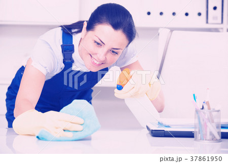 Young and smiling woman in gloves cleaning table 37861950