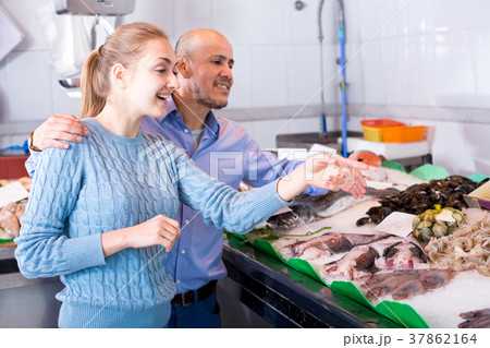 Young girl and smile man choosing in hypermarket 37862164