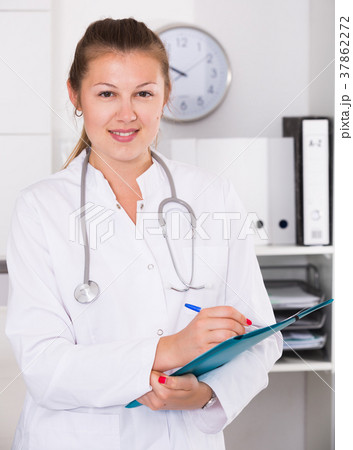 Young doctor woman is signing patient`s diagnosis Young doctor woman is signing patient`s diagnosis 37862272