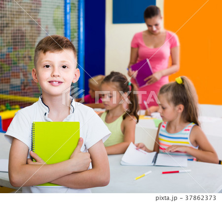 Portrait of boy holding notepad in school class 37862373