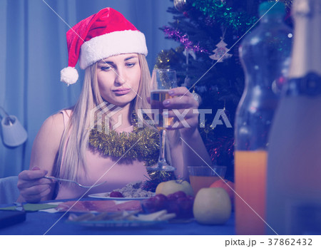 Girl is bored and drinking champagne in New Year night 37862432