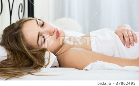 woman lying in bed under sheet with closed eyes woman lying in bed under sheet with closed eyes 37862495