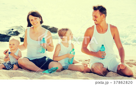 family drinking water on beach . family drinking water on beach . 37862820
