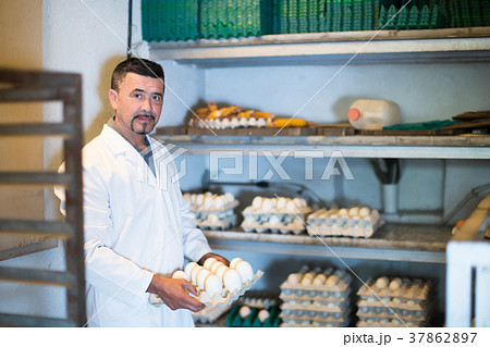 Young man working and packing white hen eggs 37862897