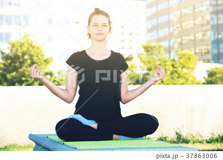 Girl in lotus pose outdoors 37863006