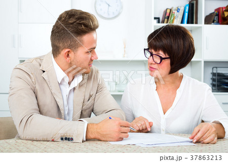 Man and mature woman sit at table 37863213