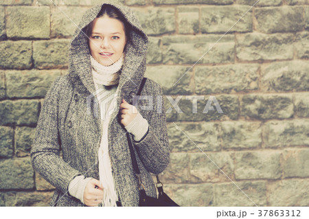 teenager girl in hood near wall teenager girl in hood near wall 37863312
