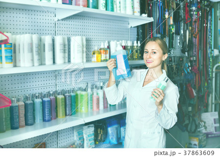 Young woman seller showing types of pet shampoo Young woman seller showing types of pet shampoo 37863609