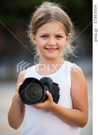 Girl taking pictures with professional camera outdoors Girl taking pictures with professional camera outdoors 37863934