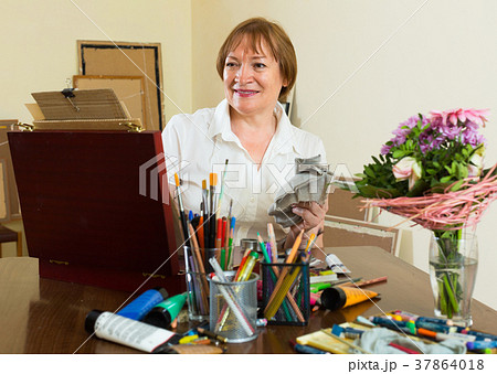 Elderly woman painting for fun at home Elderly woman painting for fun at home 37864018