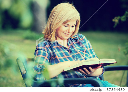 woman reading outdoors woman reading outdoors 37864480