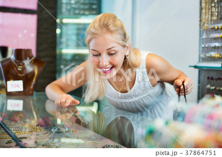 Portrait of young woman standing next to glass showcases 37864751