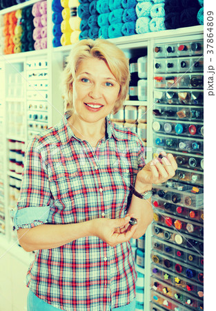 Mature glad woman customer picking various buttons Mature glad woman customer picking various buttons 37864809