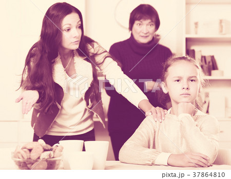 Upset girl scolded by mother and grandma 37864810