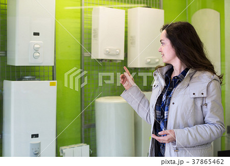Woman choosing heating water converter. Woman choosing heating water converter. 37865462