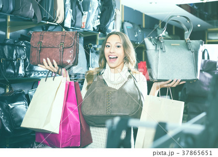 Young satisfied woman buying leather purse in shop 37865651