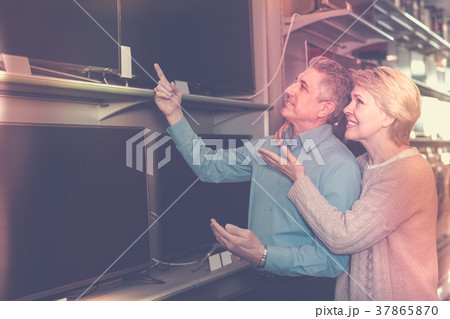 glad husband and wife choose for themselves TV in center of electronics 37865870