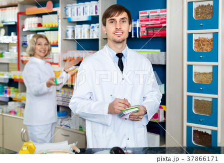 Portrait of two pharmacists working in modern farmacy Portrait of two pharmacists working in modern farmacy 37866171
