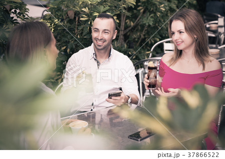 Man with two young women are talking about life and lunching Man with two young women are talking about life and lunching 37866522