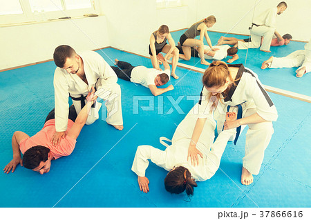 trainees sparring in pairs to practice new holds in taekwondo cl 37866616