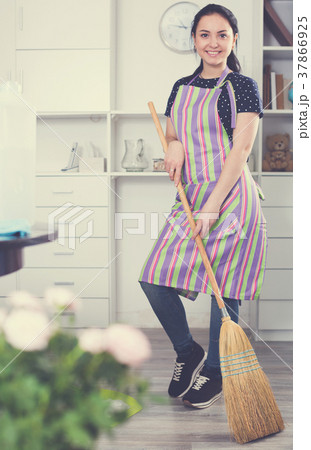 Cheerful girl sweeping floor Cheerful girl sweeping floor 37866925