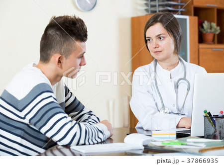 Female doctor questioning teen patient at office Female doctor questioning teen patient at office 37866935