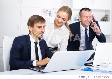 Smiling coworkers working and talking on phone 37867599