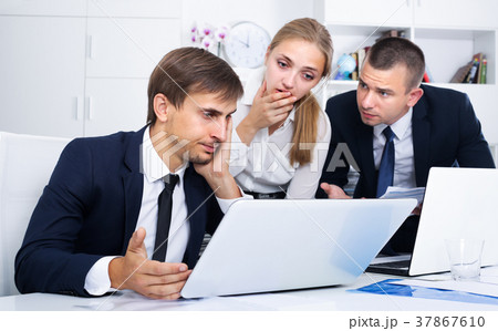 three depressed business colleagues in office . 37867610