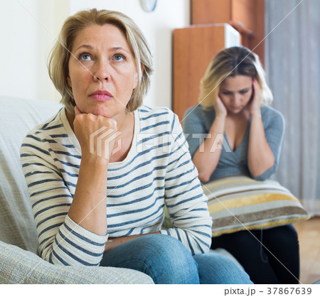 Upset young woman and senior mother having bad argue indoor Upset young woman and senior mother having bad argue indoor 37867639