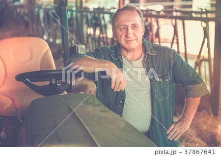 Male farm owner on tractor Male farm owner on tractor 37867641