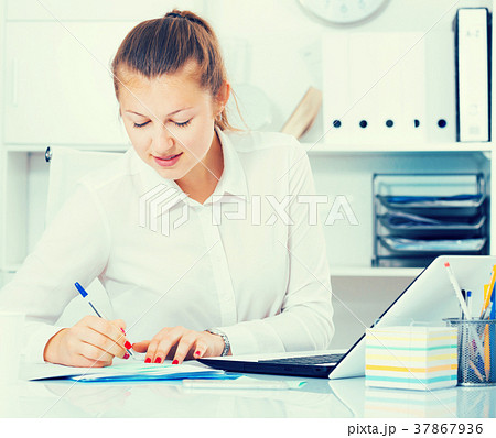Young manager is working with documents and laptop 37867936