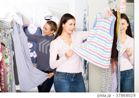 Two women selecting sleepwear in store. Two women selecting sleepwear in store. 37868029