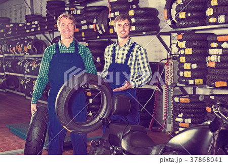 Mechanics working with new tires Mechanics working with new tires 37868041
