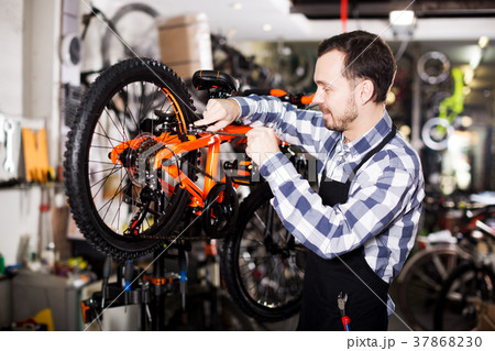 Man working on master mechanic assembling bicycle equipment 37868230