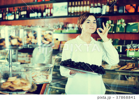 Seller offering tray of cakes Seller offering tray of cakes 37868841
