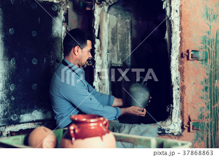 hilarious male with black-glazed ceramic vase standing close to 37868863