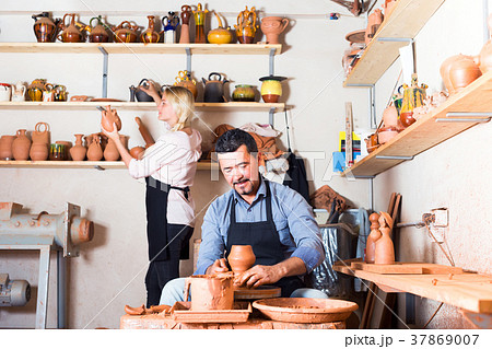 two potters working with ceramics in atelier. 37869007