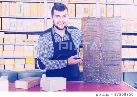 female shop assistant displaying assortment in houseware shop female shop assistant displaying assortment in houseware shop 37869350