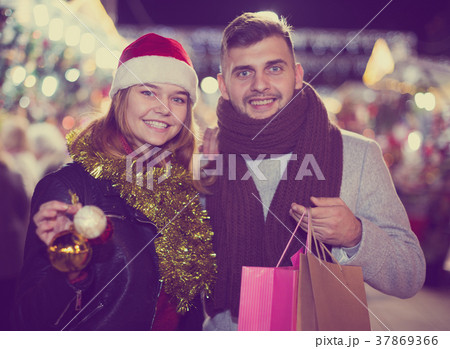 Couple in Christmas hat with purchases at Christmas Fair 37869366
