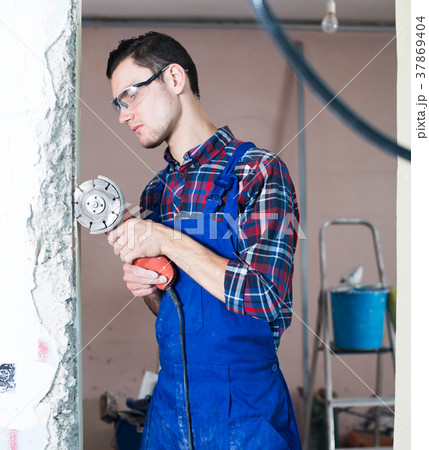 Male contractor using angle grinder 37869404