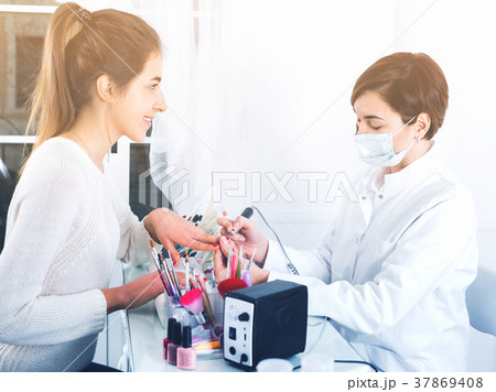 Female client doing nails in shellac technique 37869408