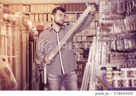 Guy choosing on best molding in houseware shop 37869409