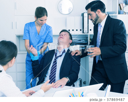 Businessman in fainting receiving first aid in office 37869487