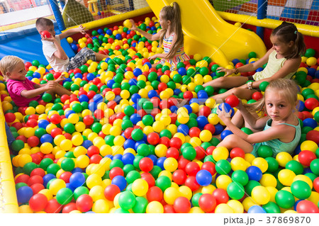 children playing together in pool with plastic multicolored balls 37869870