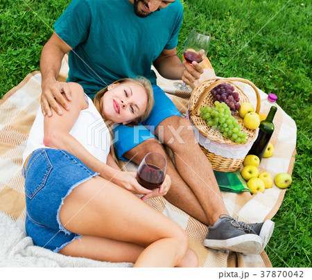 Young woman is lying on the lap of boyfriend in time picnic in the park. 37870042