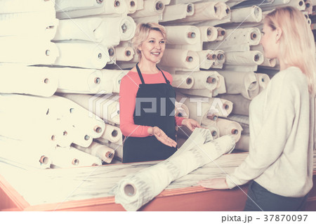 Woman seller displaying diverse fabrics 37870097