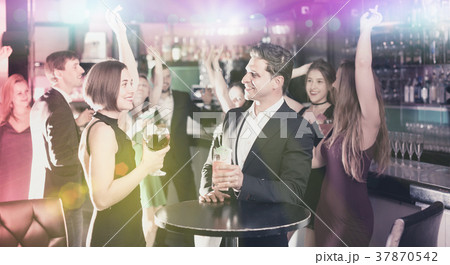 Colleagues dancing on corporate party with cocktails in hands 37870542
